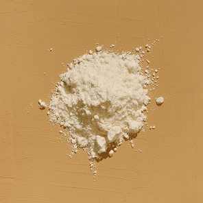 Top-down view of vitamin D powder showcasing fine off-white powder on a textured tan background